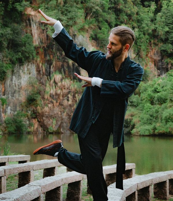 Man in a calm meditation pose with a serene natural background.